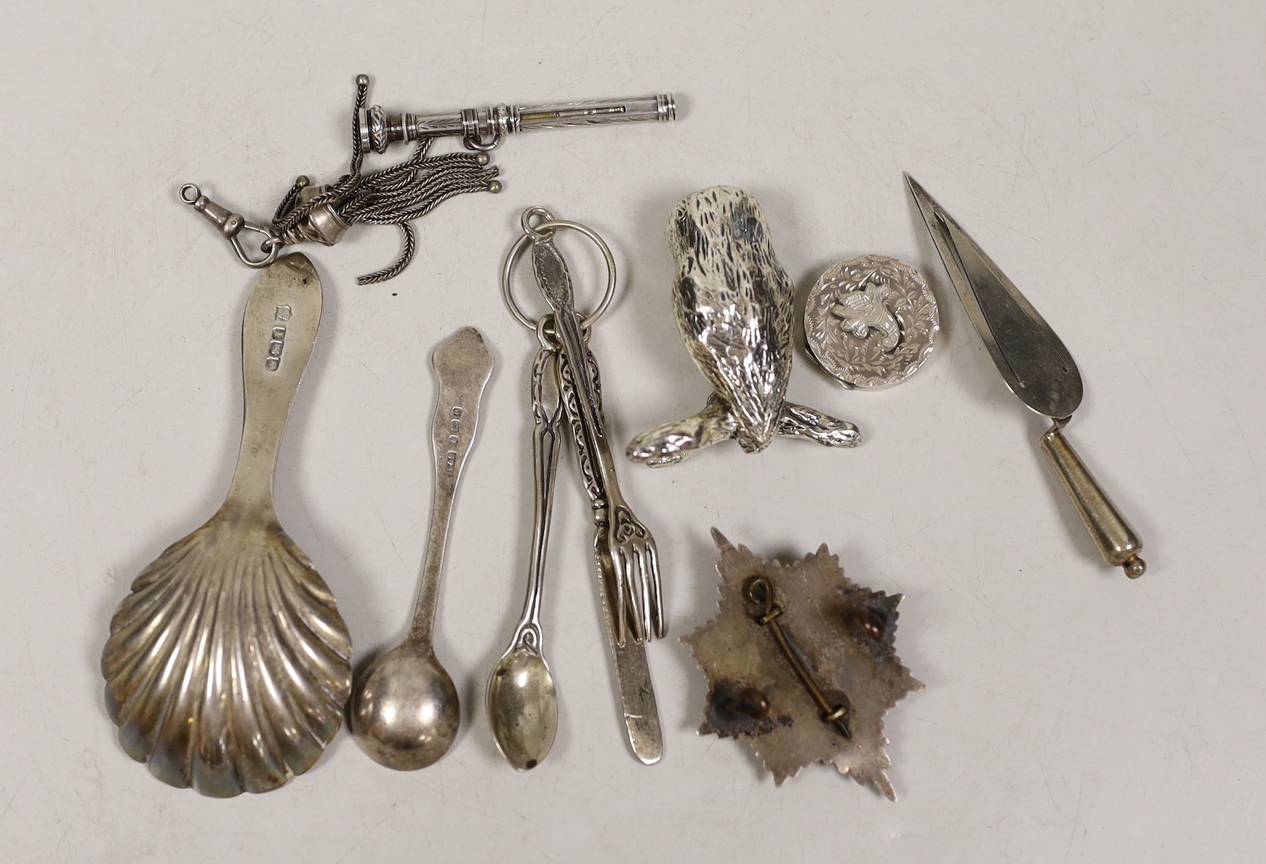 Sundry small silver etc, including a George V silver caddy spoon, a white metal badge, small cutlery and a plated owl.